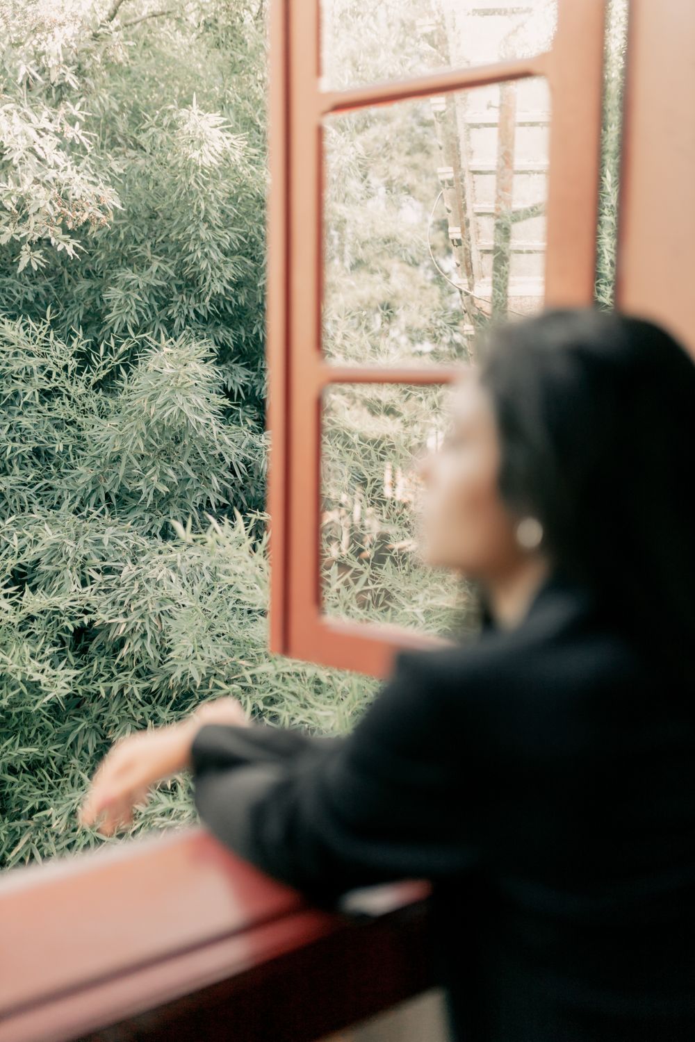 Une femme regarde la nature par une fenêtre ouverte