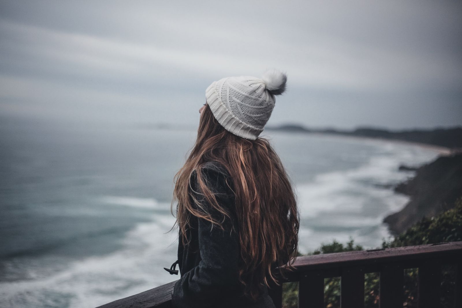 Une femme contemple l'horizon au bord de la mer