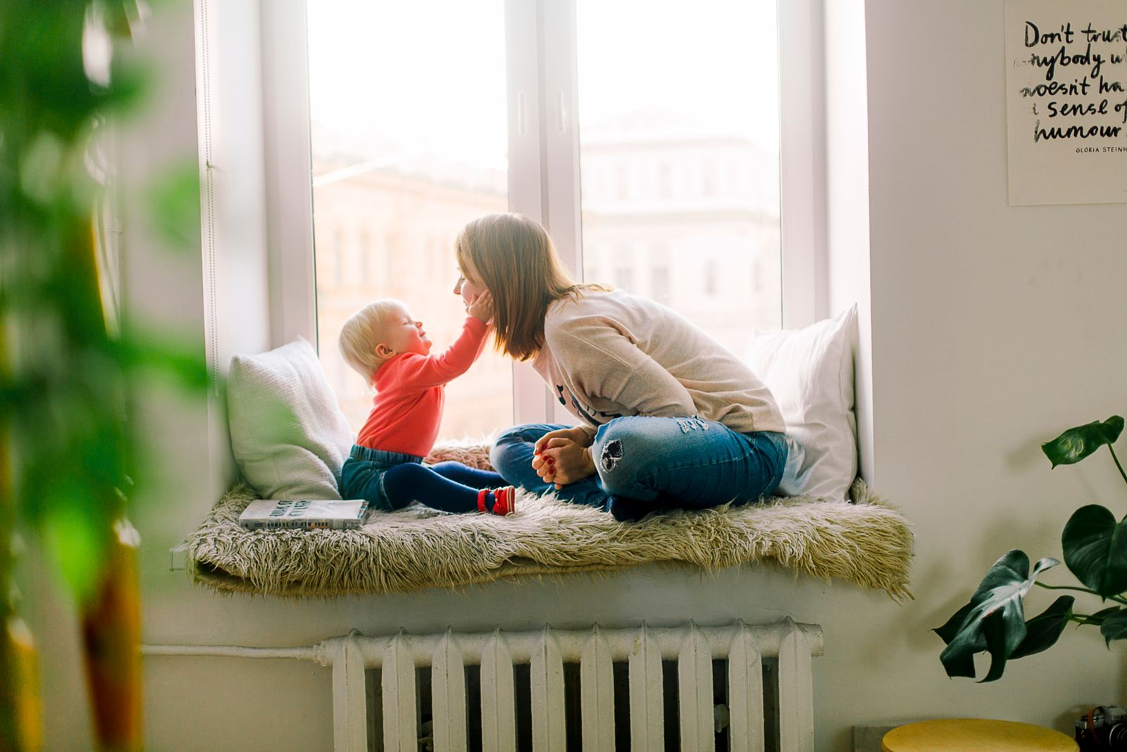 Une mère et son enfant partagent un moment tendre près d'une fenêtre lumineuse